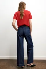 Jeans de tiro alto con diseño de cinco bolsillos, corte recto y raya planchada en el delantero y la espalda. Cierre frontal con cremallera y botón.