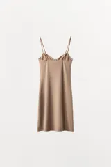 Vestido mini negro con escote corazón y aros integrados en el busto. Presenta tirantes finos ajustables y un diseño entallado con efecto reductor que estiliza la figura.