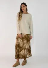 Pollera midi de corte evasé con estampado tie-dye en tonos marrones y beige, confeccionada en tela fluida.