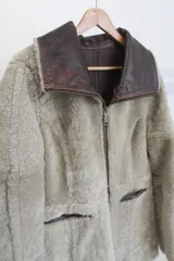 Campera reversible de cuero genuino napalán color marrón oscuro, con cuello, solapas, bolsillos frontales y detalles en corderito negro. Cierre frontal con cremallera.