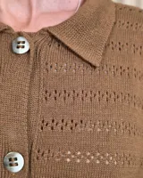 Cardigan de punto color marrón tostado, con cuello camisero, cierre frontal con botones y diseño de rayas sutiles en el tejido. Presenta mangas largas con puños elásticos y corte recto.