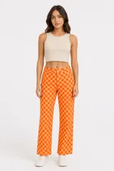 Pantalon de corte recto con estampado de tablero de ajedrez en tonos naranja y amarillo, con cierre frontal y bolsillos laterales.