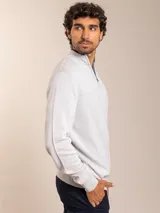 Sweater de punto en color gris claro, con cuello alto y medio cierre frontal. Presenta puños y ruedo acanalados para un ajuste cómodo.