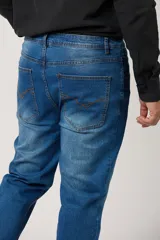 Pantalón jean clásico para hombre en color azul con efecto lavado y costuras en contraste.