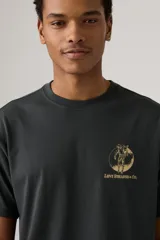 Remera negra de manga corta con estampado gráfico dorado en el pecho, que incluye el logo "Levi Strauss & Co." y la imagen de dos caballos tirando de unos jeans.