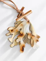 Collar con dije grande de diseño orgánico en tono dorado envejecido, combinado con piezas de resina carey y cordón ajustable de gamuza sintética.