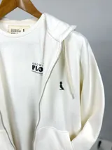 Campera con capucha color crema, con cierre frontal y bolsillos tipo canguro.