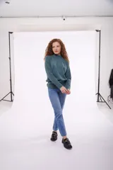 Sweater de punto color verde azulado, con cuello alto y mangas largas.