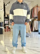 Buzo de cuello polo y medio cierre, con diseño de bloques de color en gris y blanco, de corte oversize y mangas largas.