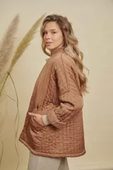 Campera tipo kimono acolchada en color azul petróleo, con diseño de costuras verticales y bolsillos frontales amplios. Presenta mangas largas con puños vueltos y un corte holgado y abierto.