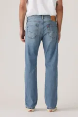 Pantalón de jean corte regular, con diseño clásico de cinco bolsillos, cierre de botón y cremallera, en tono azul medio con acabado desgastado.