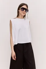 Musculosa blanca de corte cropped y recto, con cuello redondo y hombros estructurados.