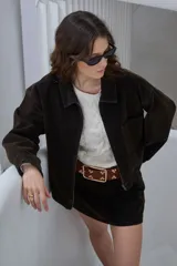 Campera manga larga de jean color marrón, con cuello camisero, cierre frontal y bolsillos en el pecho.