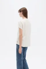 Blusa de viscosa color blanco, de corte holgado, con cuello en V y cierre frontal parcial de botones grandes con efecto carey.