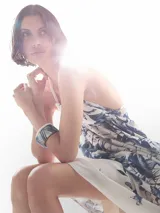 Vestido largo blanco con estampado floral azul, escote halter y corte acampanado.