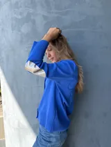 Cárdigan azul con botones, tejido en hilo y apliques plateados en los codos.