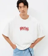 Remera de corte oversized confeccionada en mezcla de algodón y poliéster, con cuello redondo y mangas cortas. Presenta un estampado frontal con lettering estilo gótico y un estampado de esqueleto en la espalda.