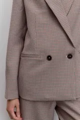 Blazer de corte sastrero con diseño cruzado y cierre de doble botonadura frontal. Presenta solapas clásicas y bolsillos laterales con solapa, confeccionado en tela con estampado de cuadros pequeños.