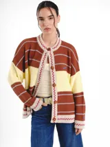 Cardigan tejido de punto jacquard en tonos bordó y rojo con rayas, de corte oversize, cuello redondo y cierre frontal con botones carey. Presenta detalles bordados en contraste y monograma en la espalda.