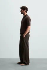 Polo de manga corta, color azul medio, tejido en punto perlado con cuello solapa y cierre frontal de cremallera.