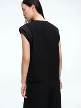 Top sin mangas de corte recto y silueta ligera, con detalle de tejido satinado en los hombros. Presenta cuello redondo y diseño minimalista.