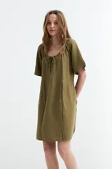 Vestido corto fluido de gasa de algodón color verde militar, con mangas cortas, escote redondo con cordón ajustable en el centro y costura fruncida en la cintura.