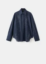 Camisa azul marino de lyocell y poliéster, con cuello camisero, manga larga, cierre frontal oculto con tapeta y detalles de apliques de strass y cristal en la parte delantera y las mangas.