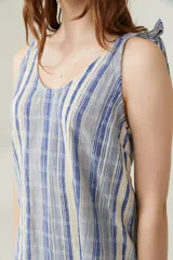 Musculosa de tejido ligero con estampado de rayas verticales en tonos azules y beige. Presenta escote redondo y breteles finos anudados en los hombros.
