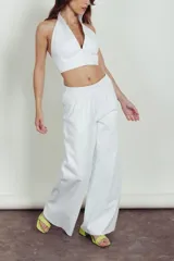 Pantalón de cuero color chocolate con corte recto y holgado. Presenta cintura elástica con cordón ajustable y costuras horizontales en la parte inferior de las piernas.