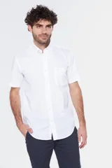 Camisa blanca de manga corta con cuello abotonado (button-down) y un bolsillo de parche en el pecho con un pequeño logo bordado.