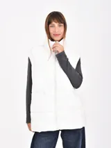 Chaleco puffer color blanco con cuello alto y cierre frontal.