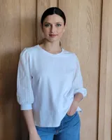 Remera de algodón con cuerpo liso y mangas abullonadas de tela con textura bordada y puños ajustados.