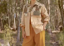 Chaqueta color beige con estampado abstracto en tonos amarillos, con cuello camisero, cierre frontal con botones, bolsillos plaqué y puños camiseros.