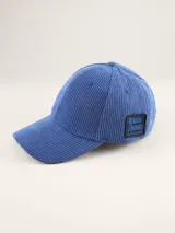 Gorra tipo baseball confeccionada en pana color azul marino, con parche rectangular lateral que incluye el logo de la marca Benson & Thomas.
