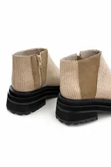 Botín color beige con textura acanalada, paneles laterales de gamuza color camel y suela track color negro.