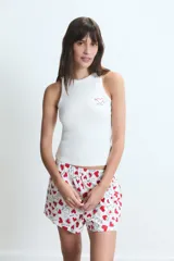 Pijama compuesto por una musculosa blanca de cuello redondo con pequeño bordado en el pecho y un short estampado con corazones rojos y texto sobre fondo blanco, con cintura elástica.