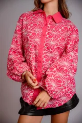 Camisa de manga larga con diseño abullonado, confeccionada en tela bordada con motivos florales. Presenta cierre frontal con botones y puños elásticos.
