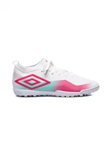 Championes Umbro modelo Vibe TF para hombre, color blanco con detalles en fucsia y turquesa en degradé. Presentan el logo Umbro en forma de rombo en el lateral y suela con tapones bajos para césped artificial o fútbol 5.