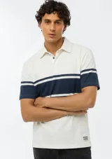 Polo de manga corta color blanco con franjas horizontales en azul marino en el pecho y las mangas. Cuenta con cuello clásico y cierre frontal de botones.