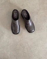 Zueco de cuero negro con punta redondeada y taco cuadrado de 4.5 cm. Diseño tipo mule con plantilla acolchada y marca Lucy in the Sky.