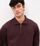 Buzo Marfinno de malla pesada color bordó, con cuello polo y cierre frontal medio, de manga larga, calce recto y puños y bajo ajustados.