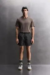 Short de entrenamiento Zara Athleticz confeccionado en tejido técnico ligero con estructura. Cuenta con malla interior, cintura elástica ajustable con cordón, bolsillos laterales y aberturas en el bajo.