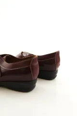 Zapato de cuero negro con cierre de velcro ancho y costuras pespunteadas a contratono.
