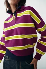 Jersey de punto con diseño de rayas horizontales en colores violeta y verde lima, cuello polo con escote en pico y manga larga con puños ajustados.
