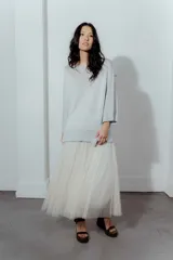 Buzo de hilo con tejido de punto fino, de corte holgado y mangas tres cuartos. Presenta un diseño versátil con cuello redondo amplio y acabado ligeramente brillante.