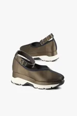 Zapato negro con base deportiva y pulsera al tobillo ajustable. Parte superior de tela satinada, forro y plantilla de piel de cerdo y suela de goma.