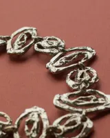 Gargantilla de diseño artesanal compuesta por eslabones de formas orgánicas y texturizadas, con cadena de ajuste posterior.