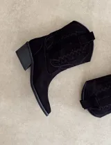 Bota corta de gamuza negra con bordados en hilo negro en la caña y puntera. Taco cuadrado y bajo.