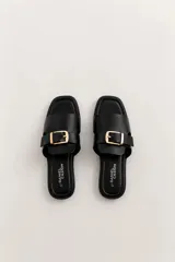 Sandalias planas color borravino con tiras cruzadas y hebilla dorada decorativa en el empeine.