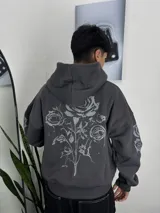Hoodie gris oscuro con cierre completo y capucha, con gran estampado reflectante de rosas en la espalda y en las mangas.